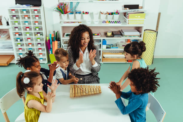 Woman playing music with preschool children
