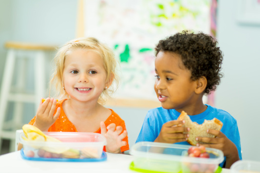 Two preschool children eating lunch